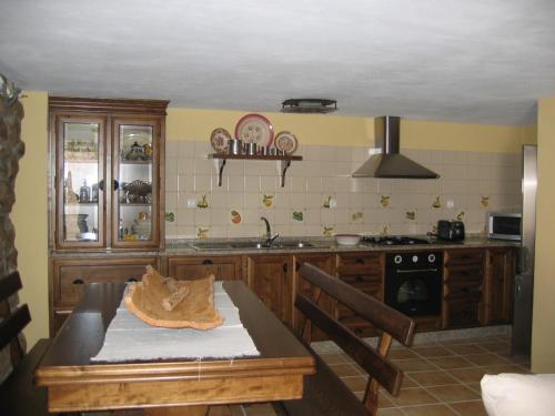 uma cozinha com uma mesa, um lavatório e um fogão em Rústica para Férias em Mirandela