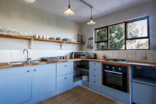 a kitchen with white cabinets and a sink at A Hilltop Country Retreat in Swellendam