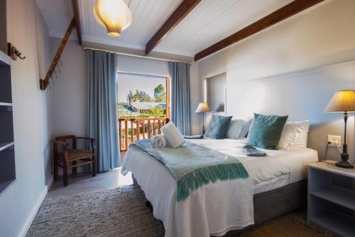 a hotel room with a bed and a balcony at A Hilltop Country Retreat in Swellendam