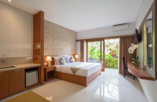 a bedroom with a bed and a sink and a television at Grand Sehati & Spa, Ubud in Ubud