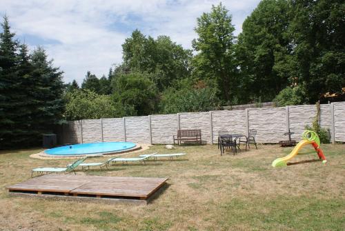 un cortile con piscina, tavolo e scivolo di U koloběžky Apartment a Slavonice