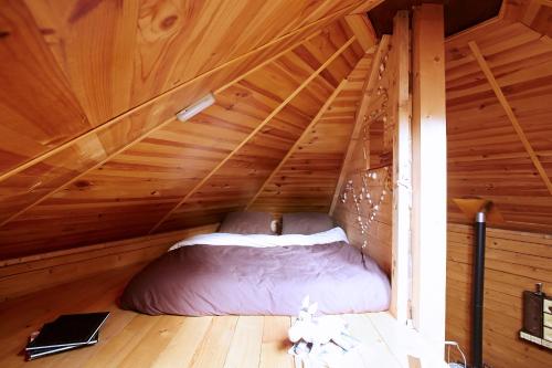Bett in einem Zimmer mit einem hölzernen Dachboden in der Unterkunft La Cab'Ane in Saint-Jean-aux-Bois