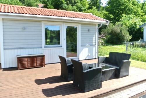a deck with chairs and a table and a building at Room by Water in Södertälje