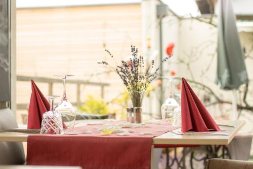 a table with red napkins and wine glasses on it at Malerwinkl Restaurant + Kunsthotel in Hatzendorf
