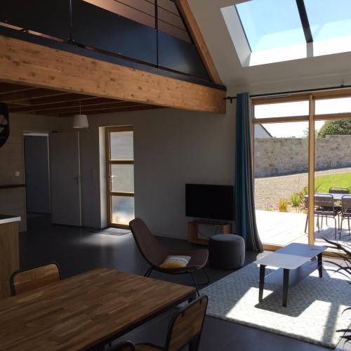 un salon avec une grande fenêtre et une table dans l'établissement Maison près des plages, à Landéda