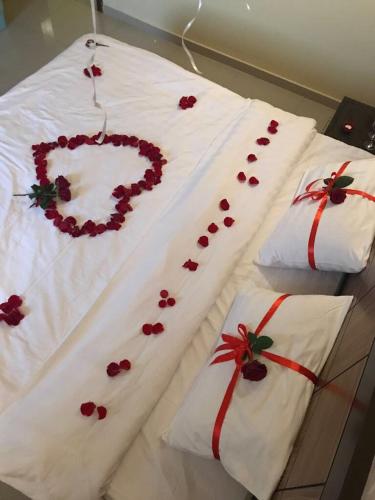 three white pillows with red flowers on them at Afaq Al Raha in Khamis Mushayt