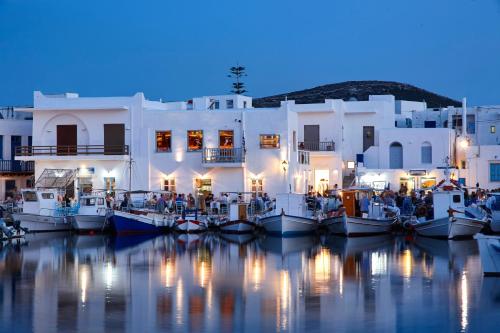 a group of boats in the water in front of a building at Mr and Mrs White Paros in Naousa