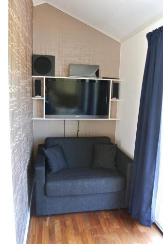a living room with a couch and a flat screen tv at Room by Water in Södertälje