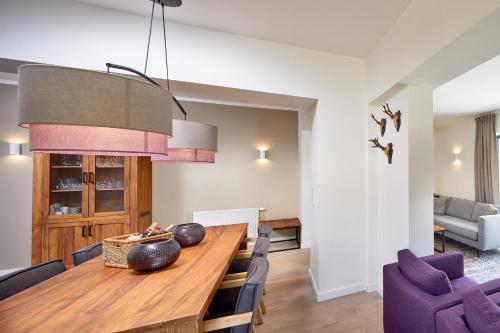 a dining room with a wooden table and purple chairs at Kristall Plaza in Niederau