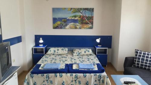 Schlafzimmer mit einem Bett mit blauem Kopfteil in der Unterkunft Blue Apartments & Suites in Ohrid