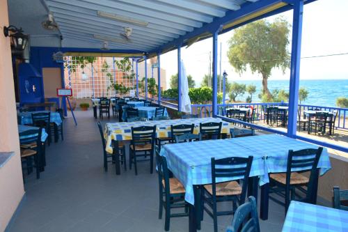 VagiaにあるAiolosの青いテーブルと椅子が備わる海の景色を望むレストラン