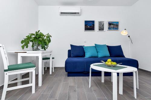 un salon avec un canapé bleu et une table dans l'établissement Apartments Franzeta, à Makarska