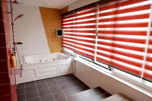 a bath tub in a bathroom with a window at V Motel Songdo in Busan