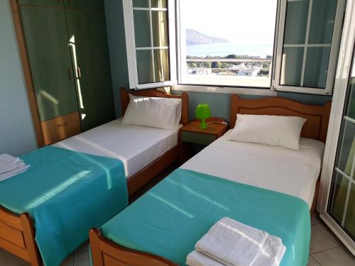 two beds in a room with two windows at Stelios Apartments in Istro