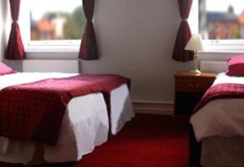 a hotel room with two beds and a window at The Griffin Hotel in Attleborough