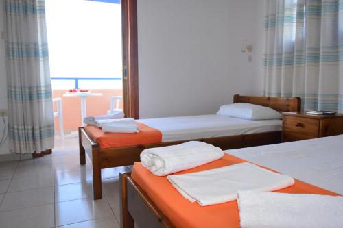 a hotel room with two beds and a balcony at Aiolos in Vaia