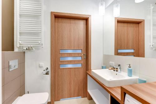 a bathroom with a sink and a toilet at INA Rent - Tre Mare Apartamenty in Gdańsk