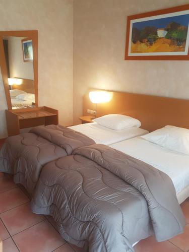 une chambre d'hôtel avec deux lits et un miroir dans l'établissement Hôtel Goélia Argelès Village Club, à Argelès-sur-Mer