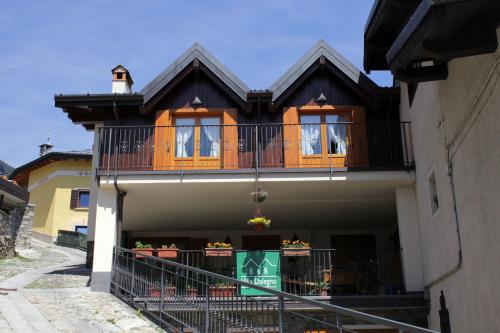 a house with a balcony on the side of it at B&B Villa Dalegno in Temù
