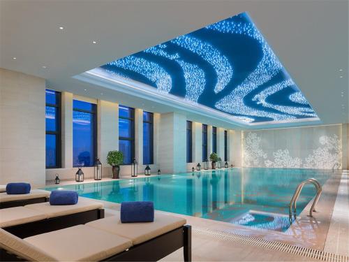 una grande piscina con soffitto blu di Wanda Realm Fushun a Fushun