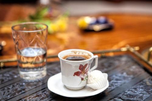 una taza de café y un vaso de agua sobre una mesa en Rosalie Palace, en Estambul