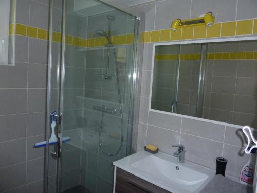 een badkamer met een glazen douche en een wastafel bij Gite La Baie Des Remparts in Saint-Valery-sur-Somme