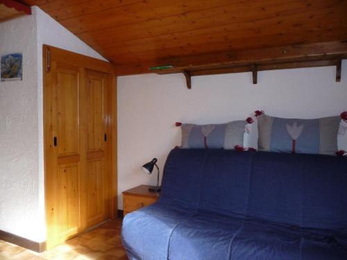 - une chambre avec un lit bleu et un plafond en bois dans l'établissement Résidence Les Jorasses, à Servoz