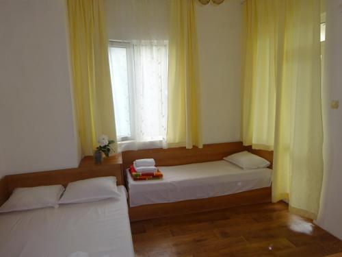 two beds sitting in a room with a window at Hris in Chernomorets