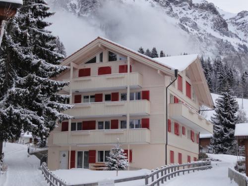 Una casa en la nieve con montañas al fondo en Chalet Brunner 3, en Wengen