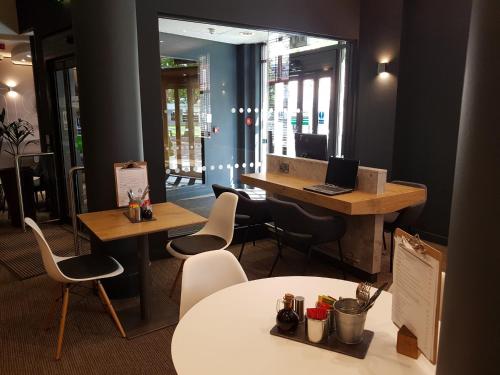 an office with tables and chairs and a laptop on a desk at Ibis Sheffield City in Sheffield