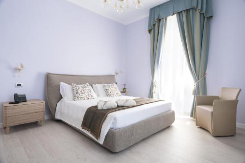 a bedroom with a large bed and a chandelier at Les 7 Suites Erica in Grado