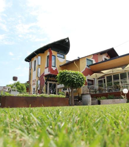 a building with a lawn in front of it at Malerwinkl Restaurant + Kunsthotel in Hatzendorf