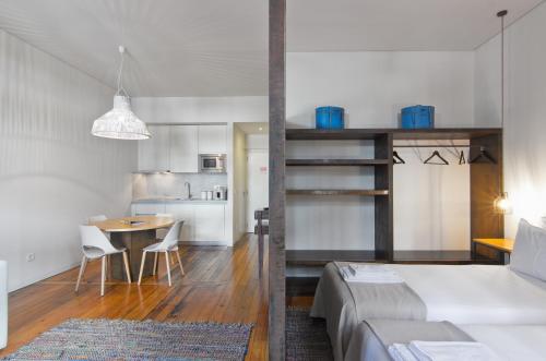 a bedroom and living room with a bed and a table at Casas do Rivoli in Porto