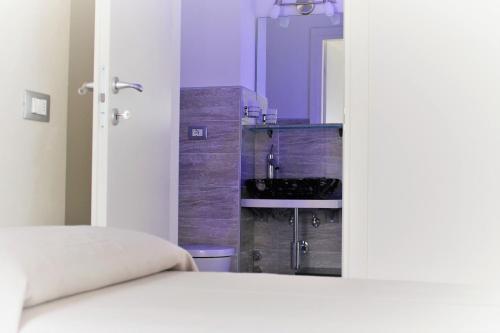 a bedroom with a bed and a bathroom with a sink at Ca' Zuliani Rooms in Chioggia