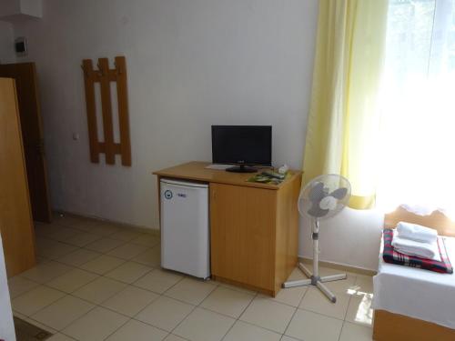 a room with a desk with a television and a refrigerator at Hris in Chernomorets