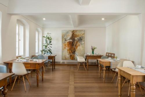a restaurant with tables and chairs and a painting on the wall at Villa Sommerach in Sommerach