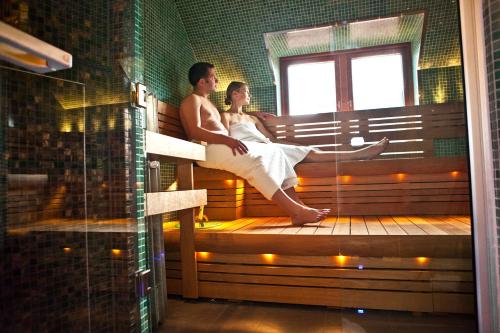 a couple sitting on a bench in a sauna at Hotell Heden - BW Signature Collection in Gothenburg