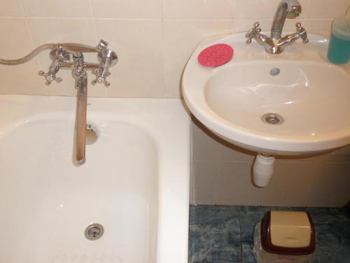 a bathroom with a sink and a bath tub next to a sink at Apartment on Nimanska 5 in Kyiv