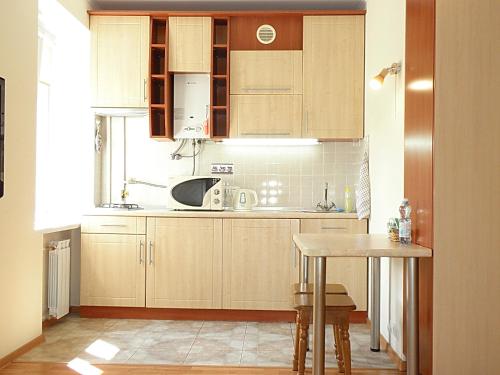 a kitchen with wooden cabinets and a table at Apartment on Nimanska 5 in Kyiv