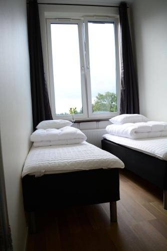 two beds in a room with two windows at Alkoven Logi in Ullared