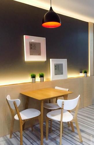 a dining room with a wooden table and white chairs at Ingnaam Hotel in Ban Talat Rangsit