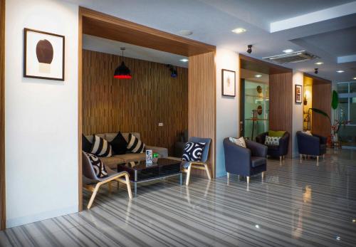 a lobby with couches and a table and chairs at Ingnaam Hotel in Ban Talat Rangsit