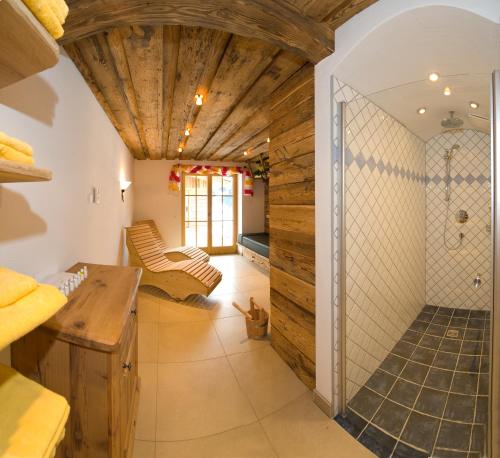 baño grande con ducha y techo de madera. en Panorama Pension en Grossarl