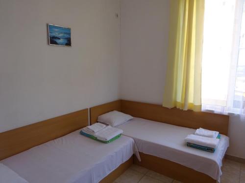 two twin beds in a room with a window at Hris in Chernomorets