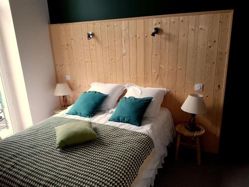 - une chambre avec un lit doté d'oreillers verts dans l'établissement Le Pavillon, à La Bourboule