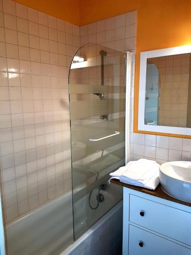 une salle de bain avec douche et lavabo dans l'établissement Le Pavillon, à La Bourboule