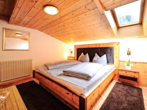 a bedroom with a large bed with a wooden ceiling at Alpenhof Pitztal in Sankt Leonhard im Pitztal