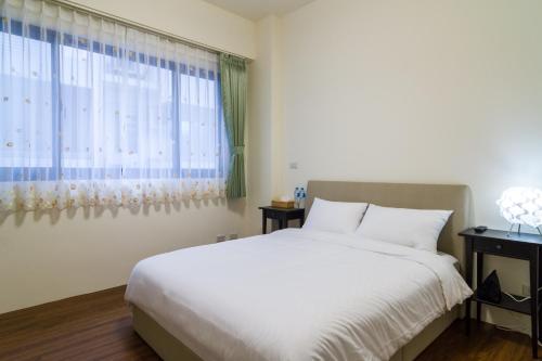 a bedroom with a white bed and a window at Wendy's home Toucheng Mansion B in Toucheng