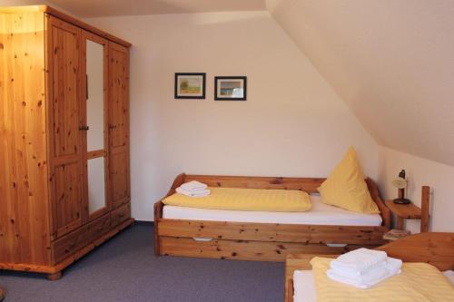 1 dormitorio con 2 camas y armario de madera en Ferienpark Arielle, en Börgerende-Rethwisch