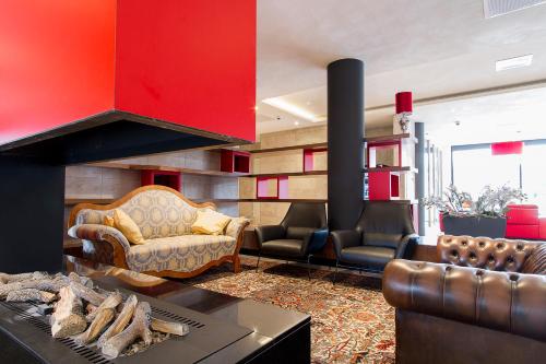 a living room with a fireplace and leather furniture at Bastion Hotel Eindhoven Waalre in Eindhoven